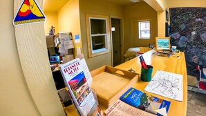 A hotel reception desk with a sign for the Silverton Mountain, a computer, and various informational brochures. - Triangle Motel (Silverton)
