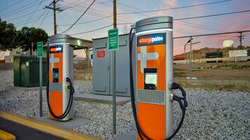 A row of orange electric vehicle charging stations with a sign indicating they are for electric vehicles only.