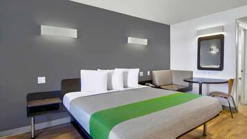 A modern hotel room with a large bed, bedside tables, a desk, and a chair.