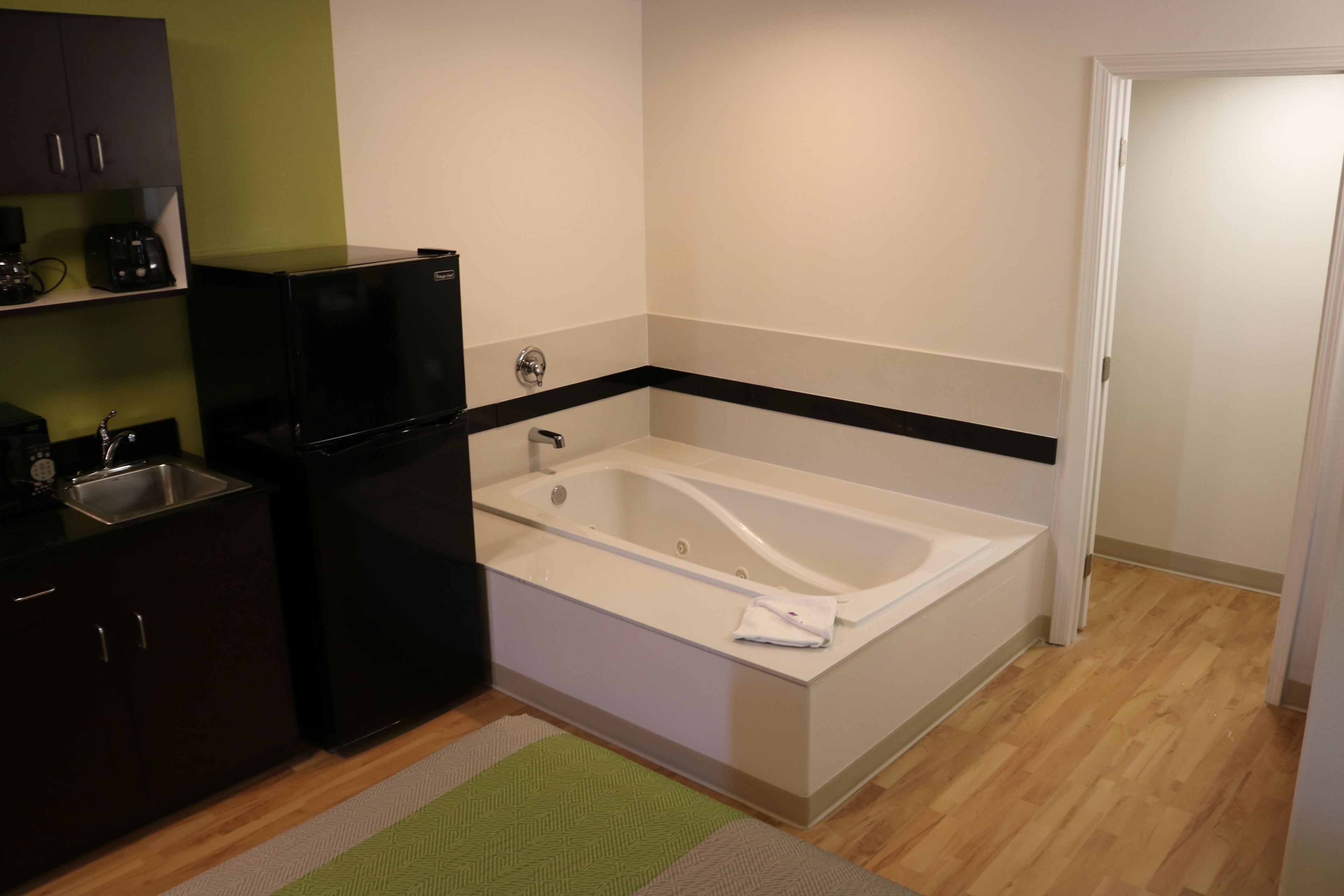 A compact kitchen with a built-in refrigerator, a sink, and a microwave.