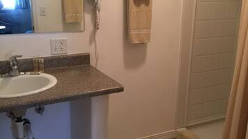 A bathroom with a sink, a hairdryer, and a towel rack.
