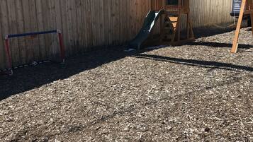 Kids can play on the outdoor play structure with a slide and soccer goal.