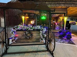 A decorated carriage with festive lights and ornaments in front of a building with a 'No Vacancy' sign.