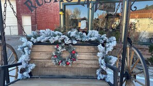 A rustic bench with a Christmas wreath and pine decorations.
