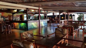 Eine Bar mit einer Theke, Hockern und einem Wandgemälde.