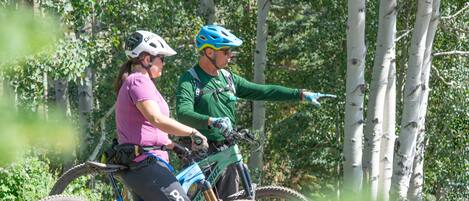 Två personer på en cykelled för mountainbikes i ett skogsområde.