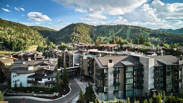 A modern resort with contemporary architecture, a central courtyard, and a scenic mountain backdrop. - Goldener Hirsch, Auberge Collection (Park City)