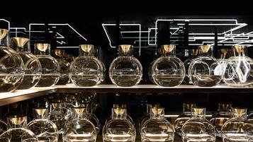 A display of clear glass bottles on shelves with a modern, illuminated background.