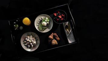 A tray with various food items including a salad, fruit, and pastries.