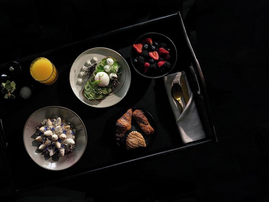 En bakke med forskelligt mad, herunder salat, frugt og kager.