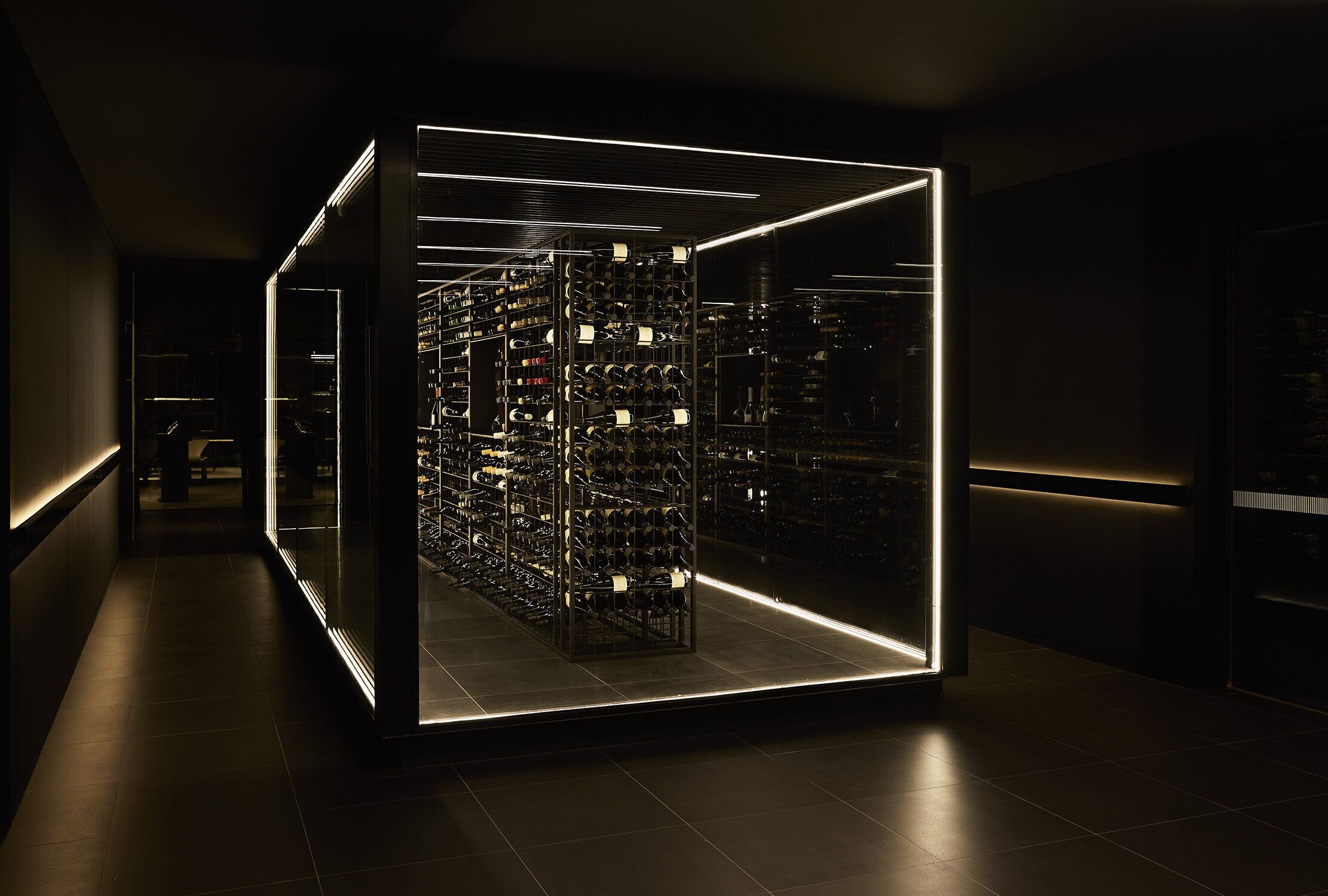 Una moderna bodega con frente de vidrio, estantes iluminados y un diseño elegante y minimalista.