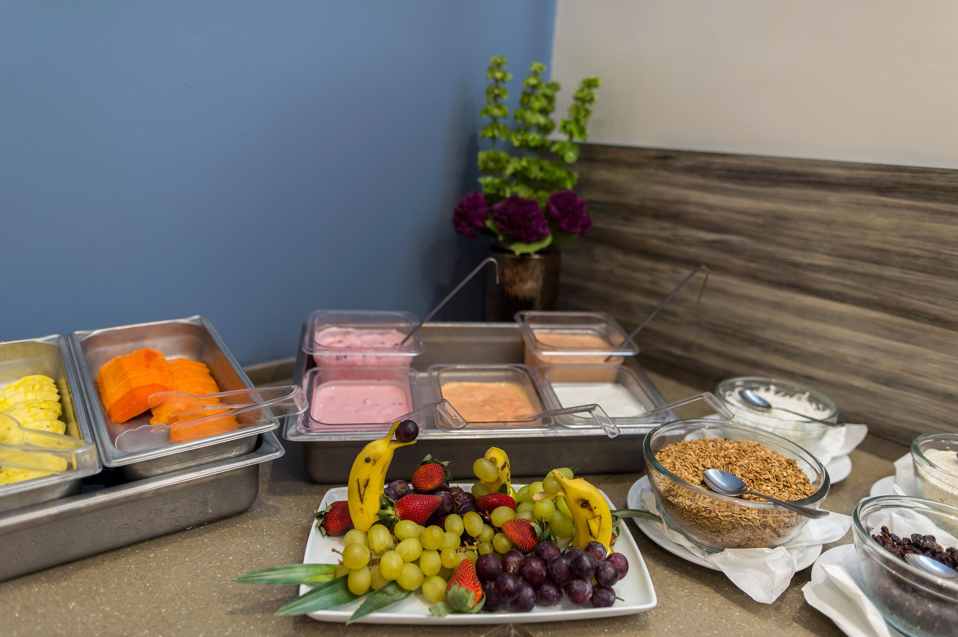 A buffet with various food items including fruits, vegetables, and desserts.
