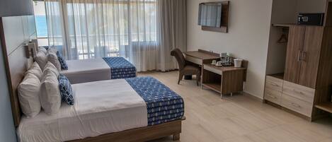 A hotel room with two beds, a desk, a chair, a TV, and a wardrobe.