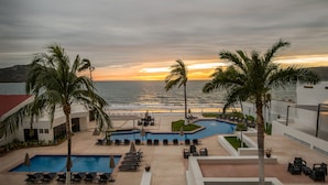 A resort pool area with multiple pools, sun loungers, and palm trees. - Ocean View Beach Hotel (Mazatlán)