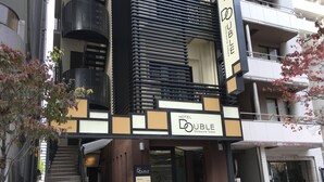 Moderni hotellin sisäänkäynti, jossa on kyltti, jossa lukee HOTEL DOUBLE Shibaura Tokyo.