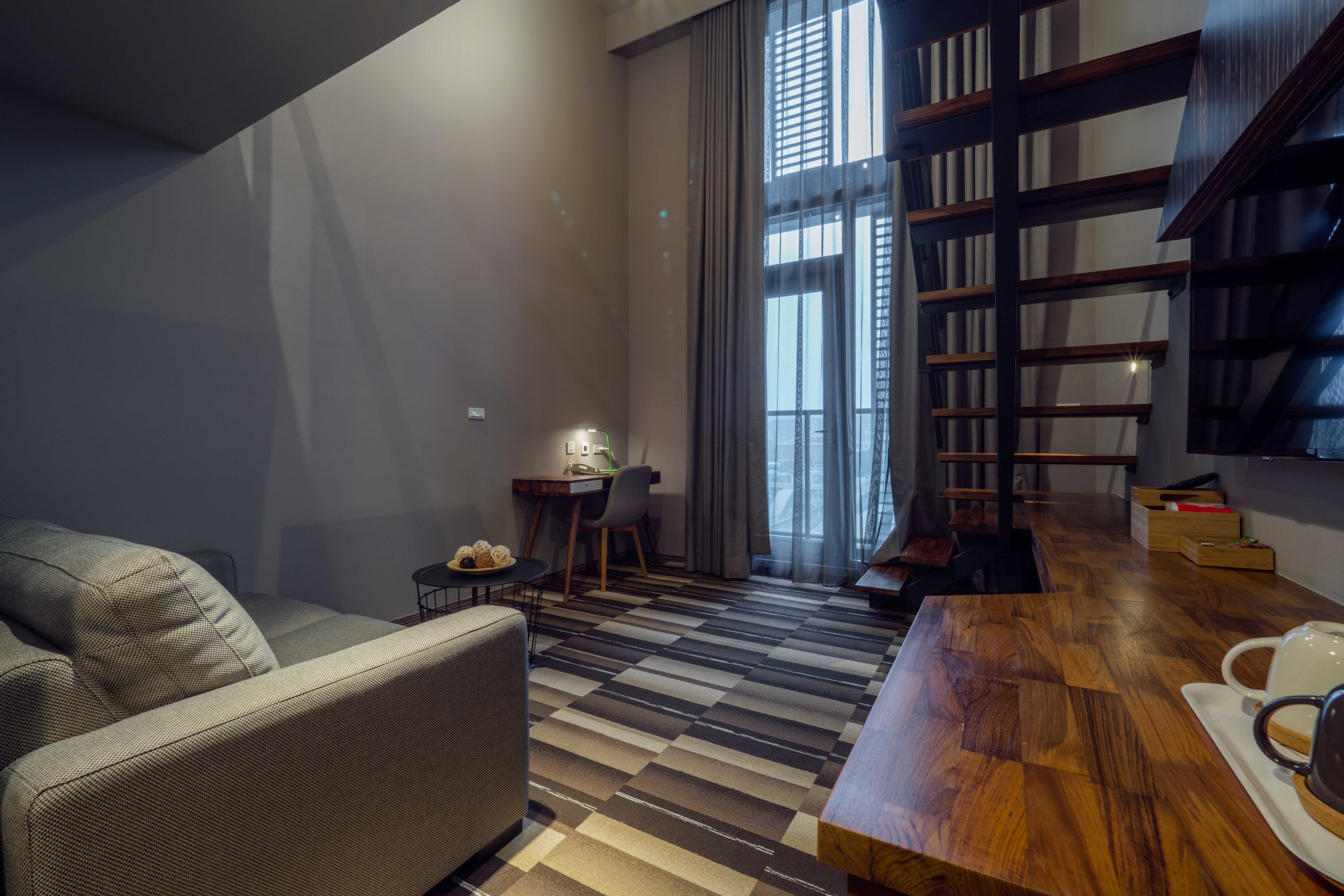 A modern living room with a sofa, a wooden coffee table, and a bookshelf.