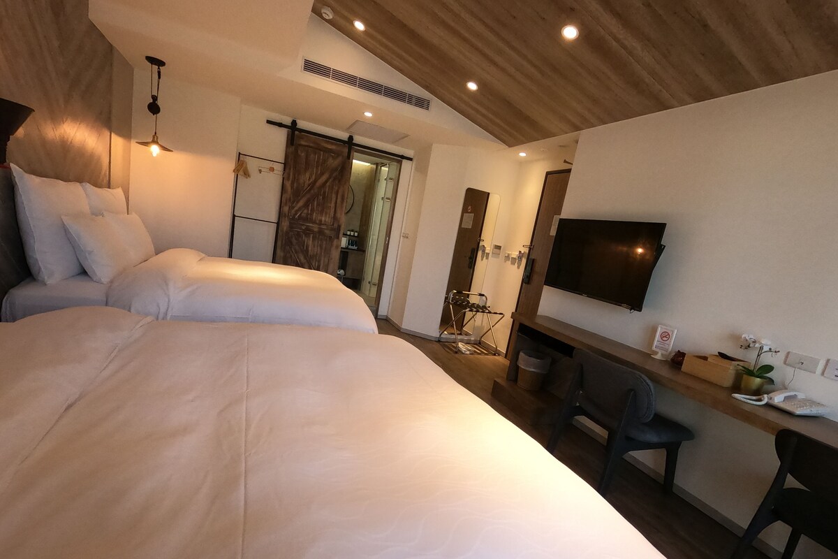 Una moderna camera d'albergo con un letto grande, una scrivania, una sedia, una televisione e un armadio.