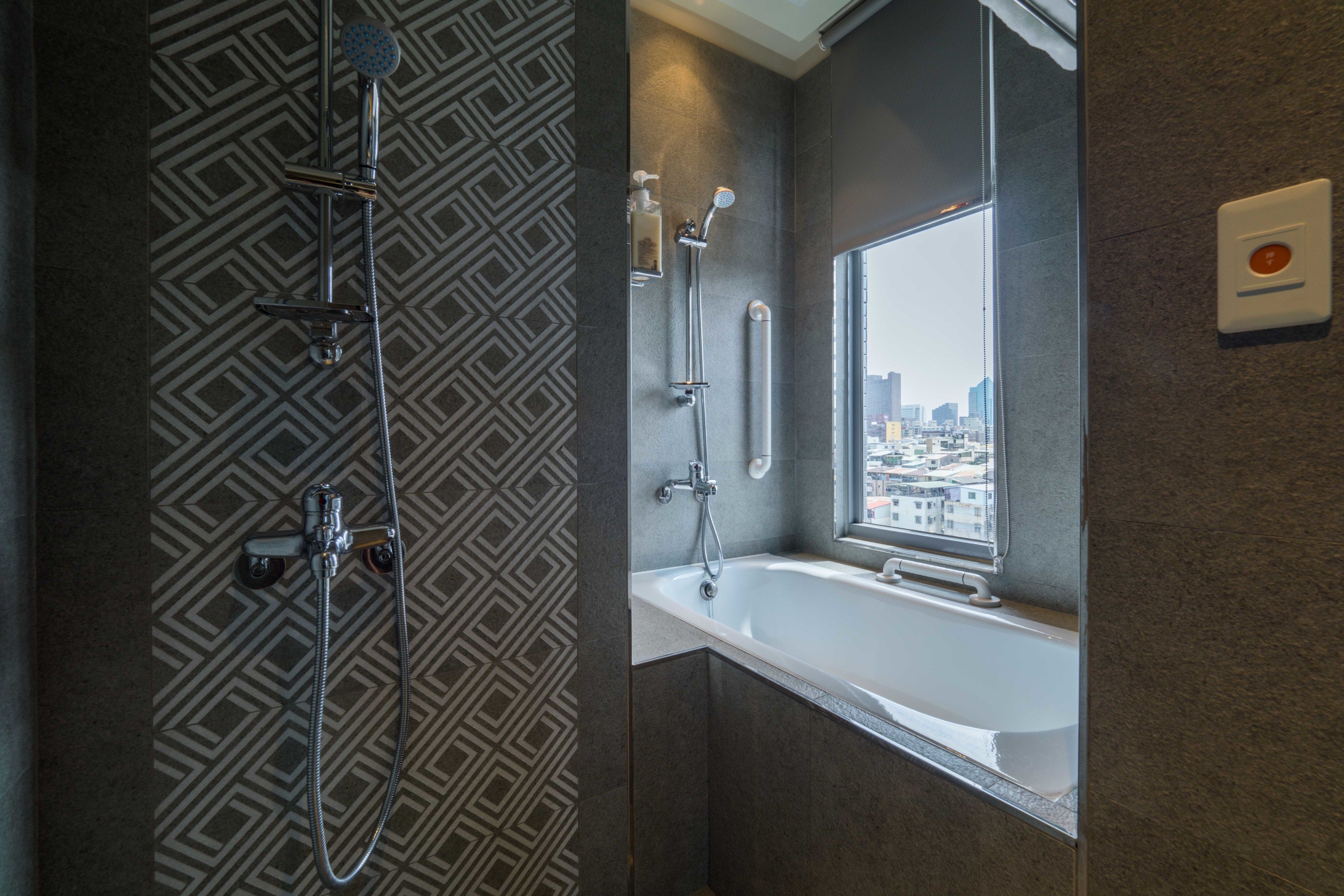 A modern bathroom with a shower, a bathtub, and a window with a city view.