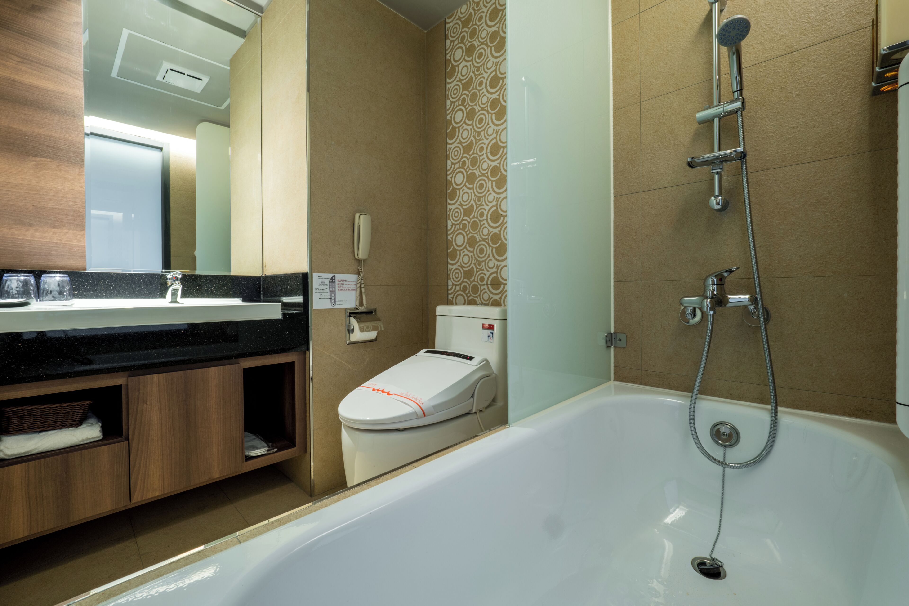 A modern bathroom with a bathtub, toilet, and vanity.
