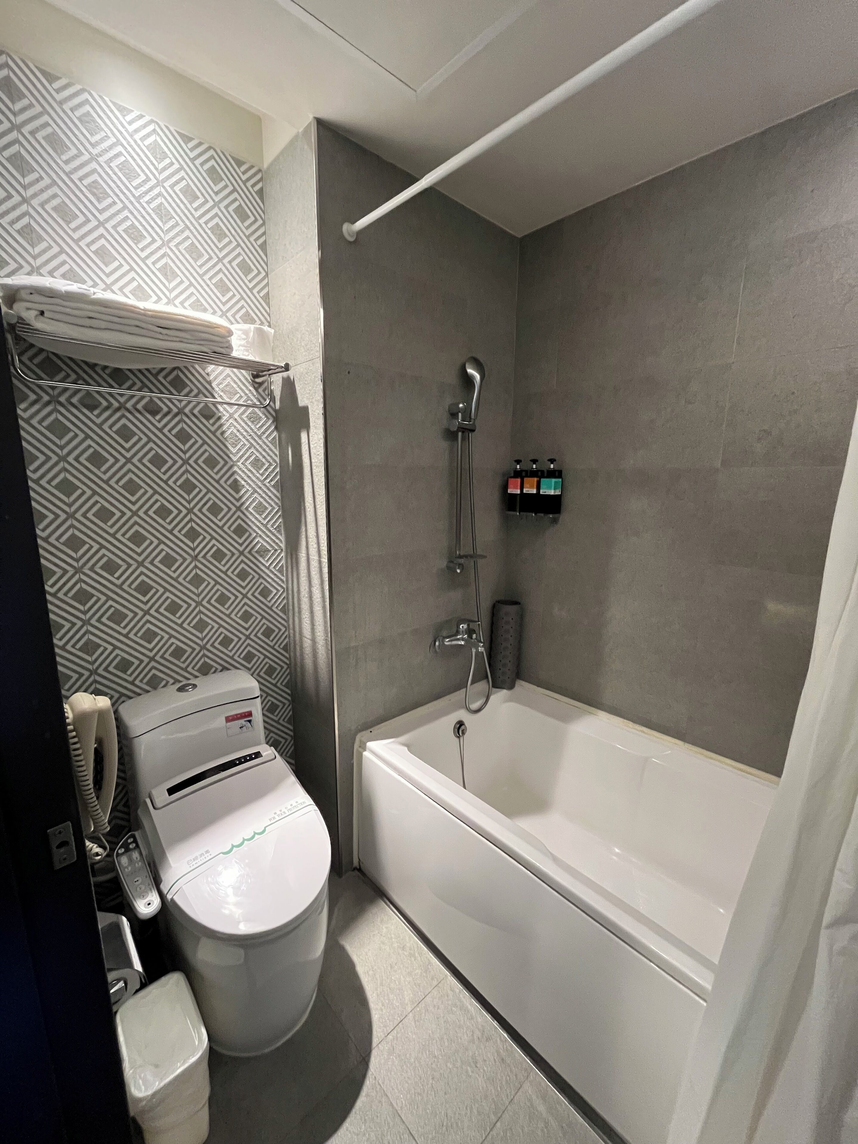 A modern bathroom with a toilet, bidet, and bathtub.