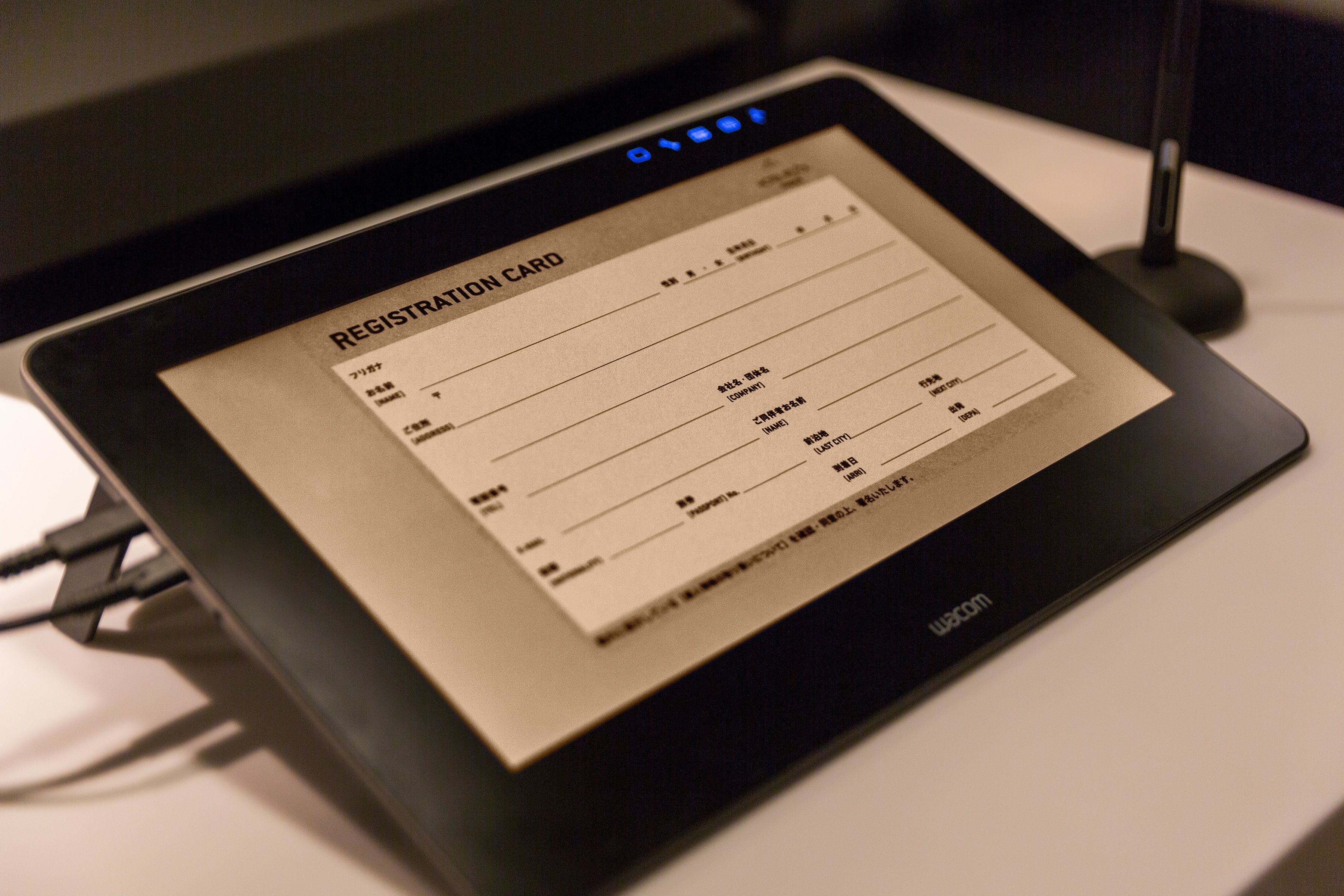 A registration card on a tablet with a USB cable connected.