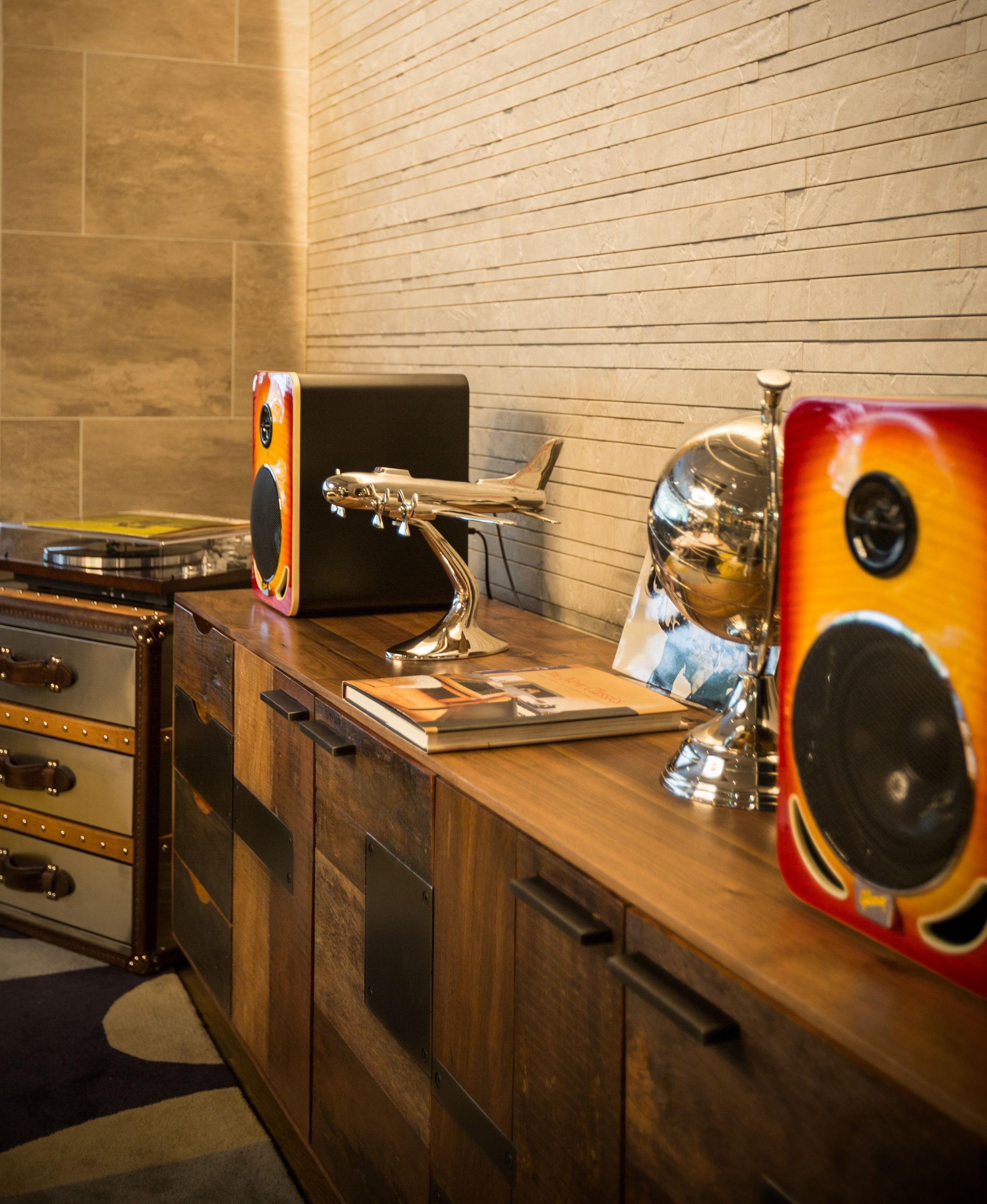 Um balcão de madeira com um rádio antigo, um livro e um objeto decorativo.