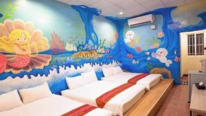 Una habitación con dos camas, un mural de una escena submarina y una ventana.