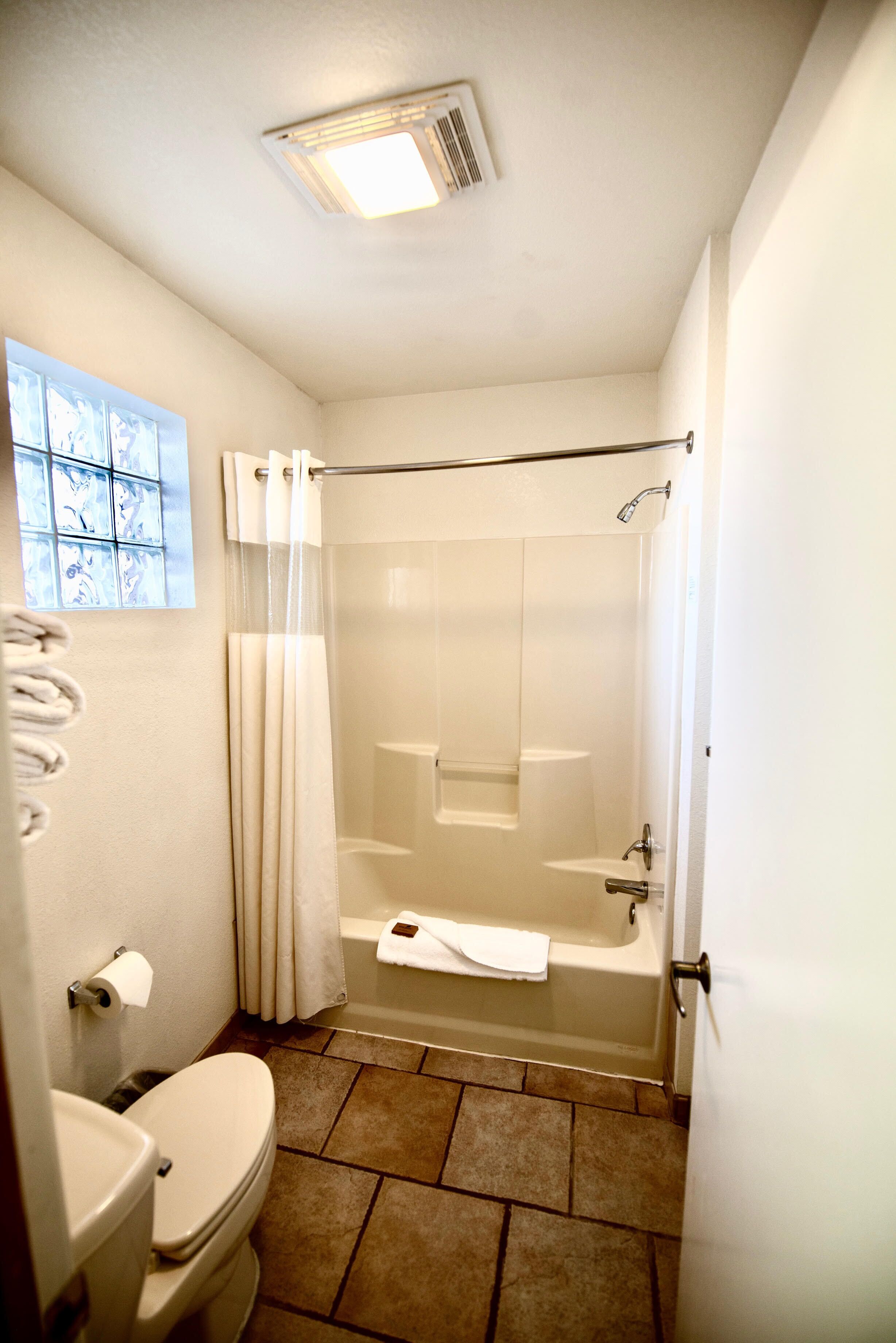A bathroom with a toilet, a shower, and a bathtub.