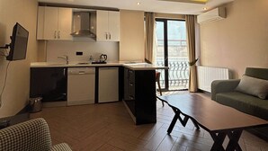 A compact living space with a kitchenette, a dining area, and a sofa. - Aldino Residence (Ankara)