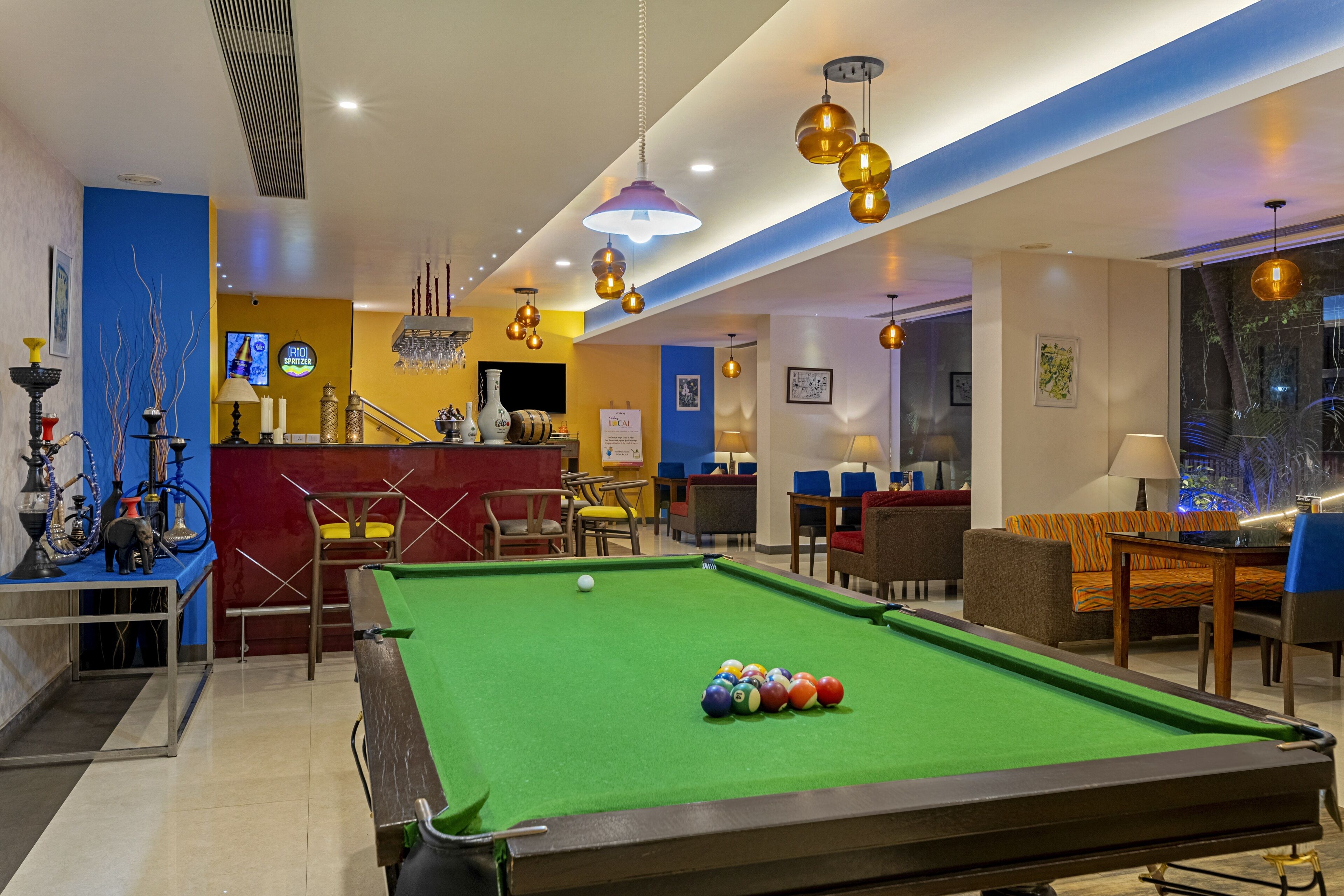 A pool table with balls, a bar area, and seating.