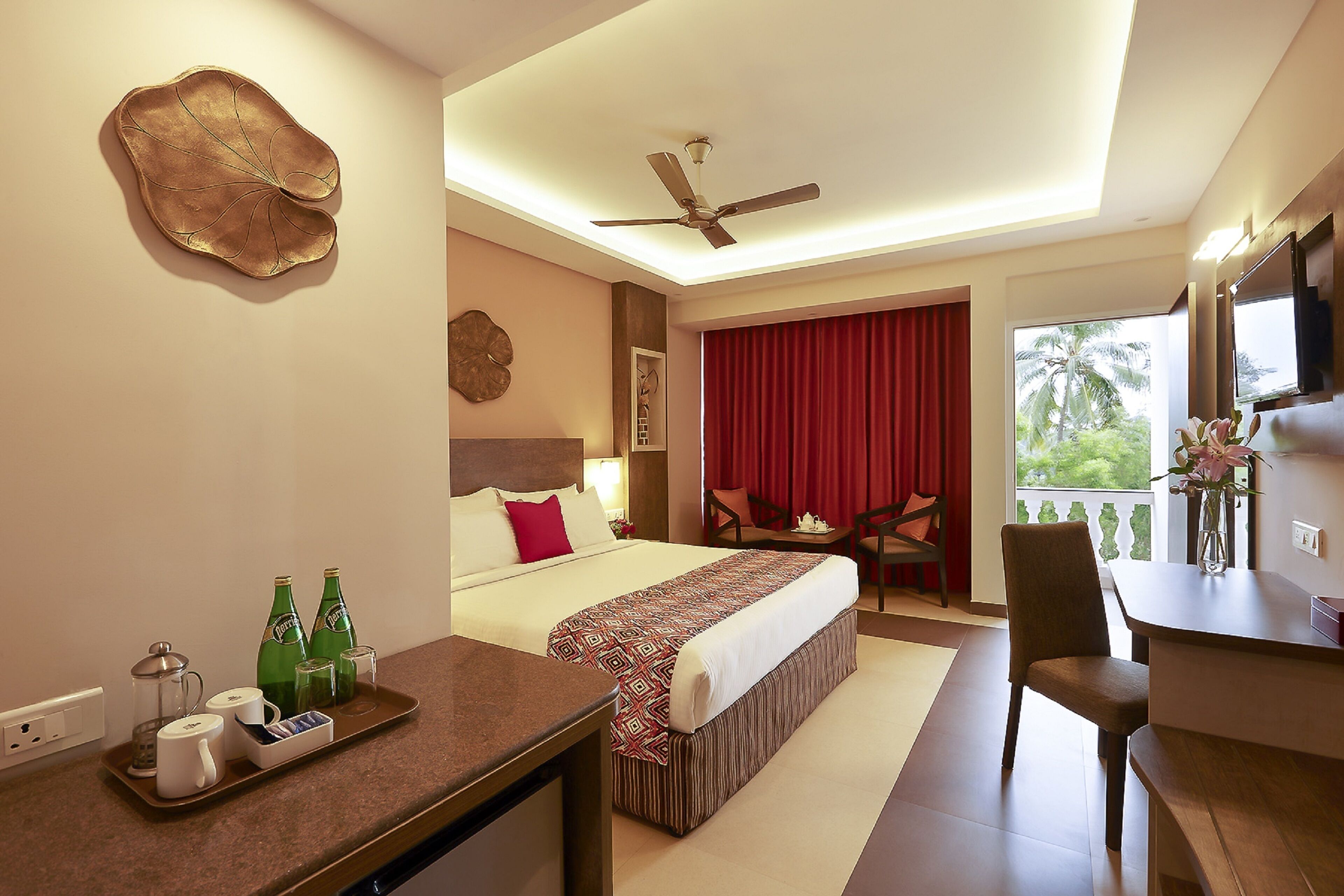 A hotel room with a bed, a desk, a chair, a dining table, and a balcony with a red curtain.