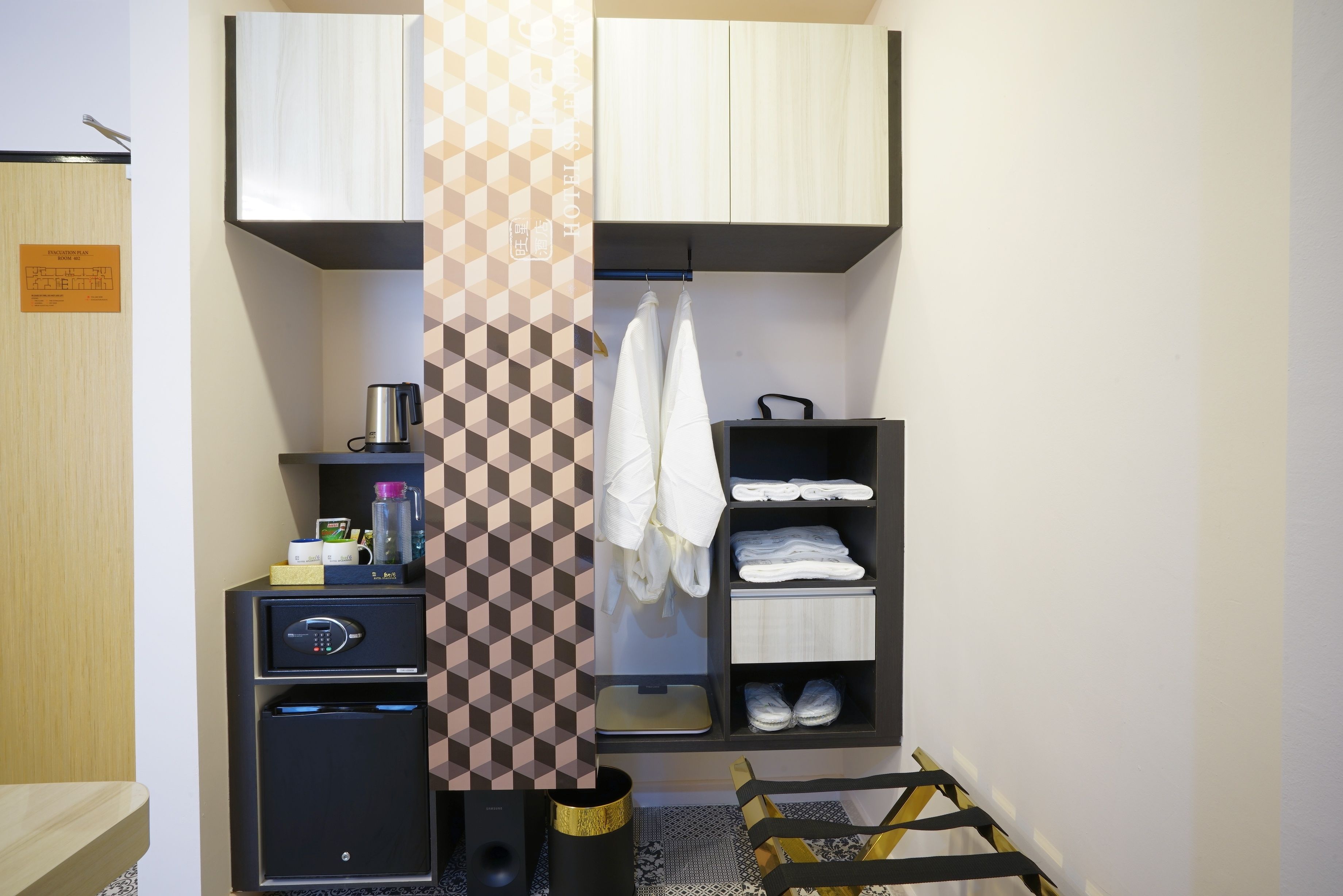 A hotel room with a minibar, a towel rack, and a shoe rack.