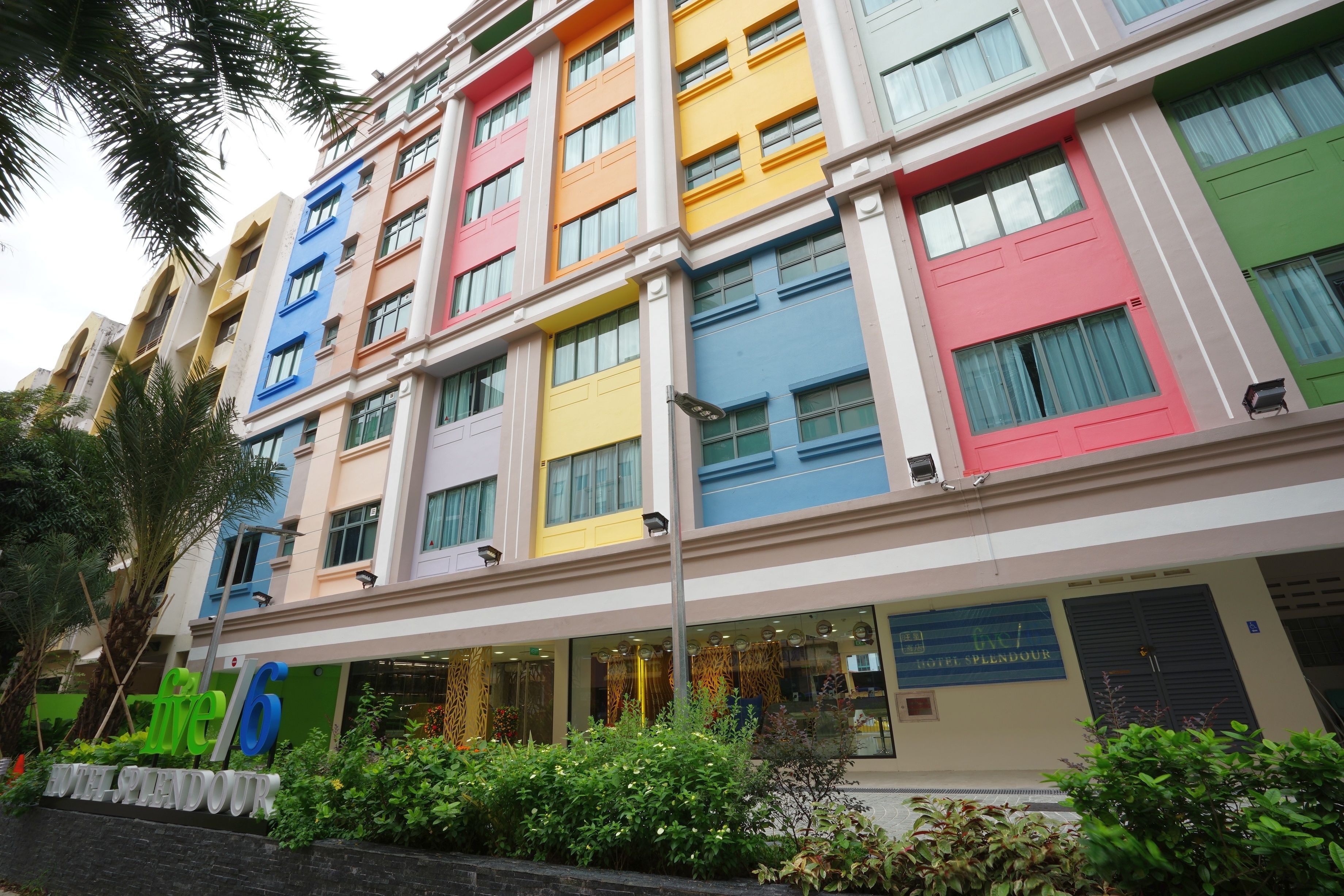 A multi-story hotel with colorful facades and a sign indicating it is the 6th hotel in a series.
