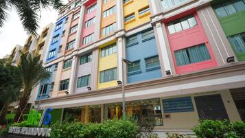 A multi-story hotel with colorful facades and a sign indicating it is the 6th hotel in a series.
