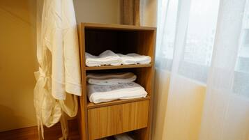 A wooden shelf with neatly folded towels and slippers.