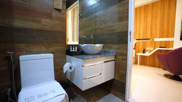 A modern bathroom with a white toilet, a vessel sink, and a wooden vanity.
