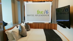 A hotel room with a bed, pillows, a TV, and a sign indicating the hotel name and room number. - five6 Hotel Splendour (Singapore)