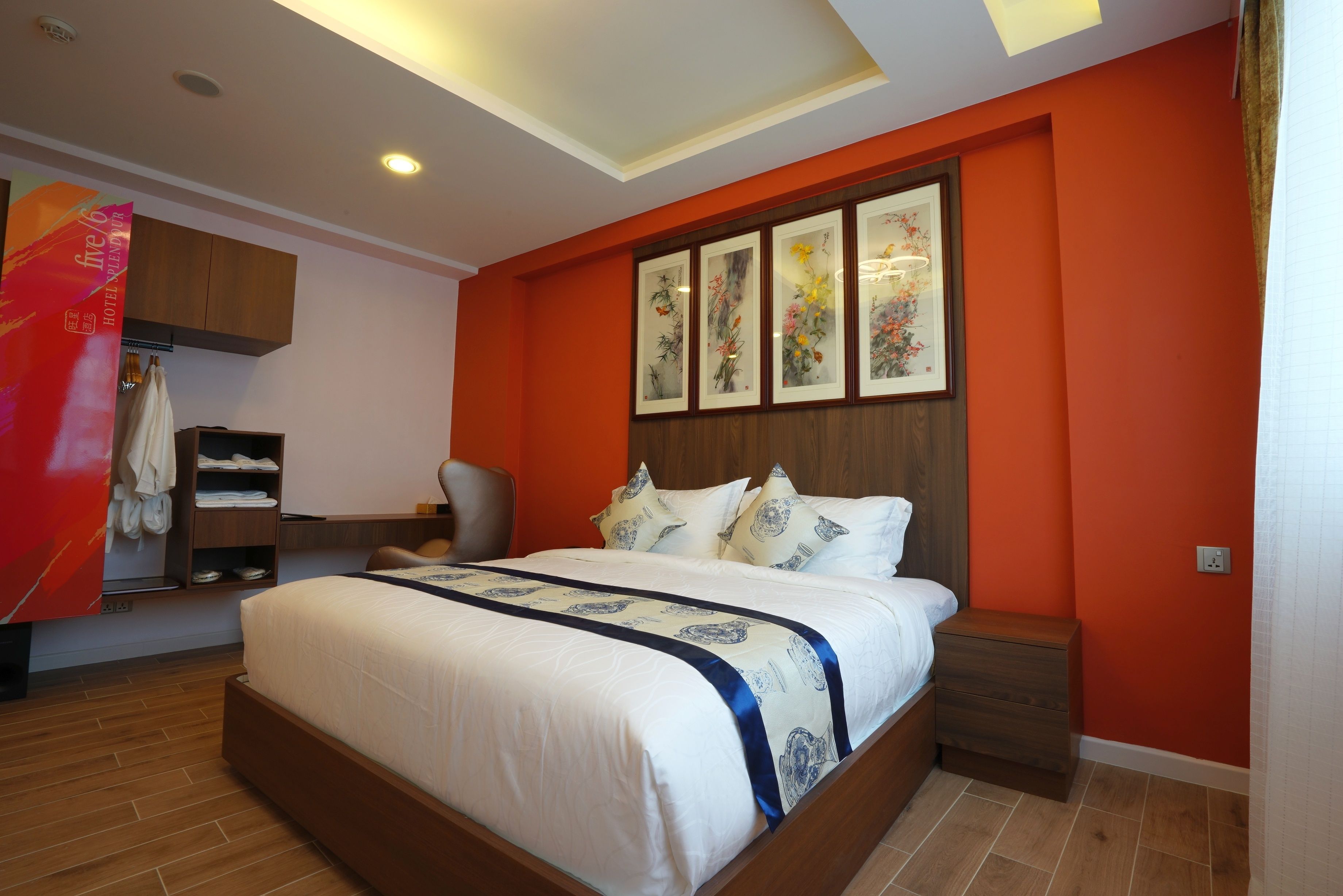 Habitación de hotel con una cama grande, cabecero de madera y estante con toallas.