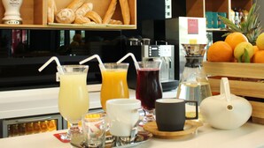 Una colazione con diverse bevande, pane e dolci in mostra.