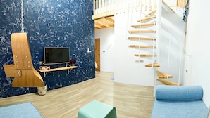 A room with a wooden play structure, a television, and a blue sofa.