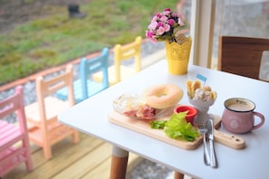 A breakfast table with a bagel, bacon, fruit, and a mug. - Fly in Sunnyday (Shoufeng)