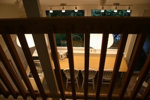 A dining area with a wooden partition, a table, and chairs. - Lilla Huset på slätten B&B (Lund)