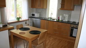 Una cocina con armarios de madera, un microondas, un fregadero y una estufa.