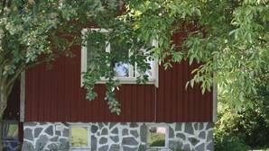 Un edificio rojo con base de piedra y una ventana.