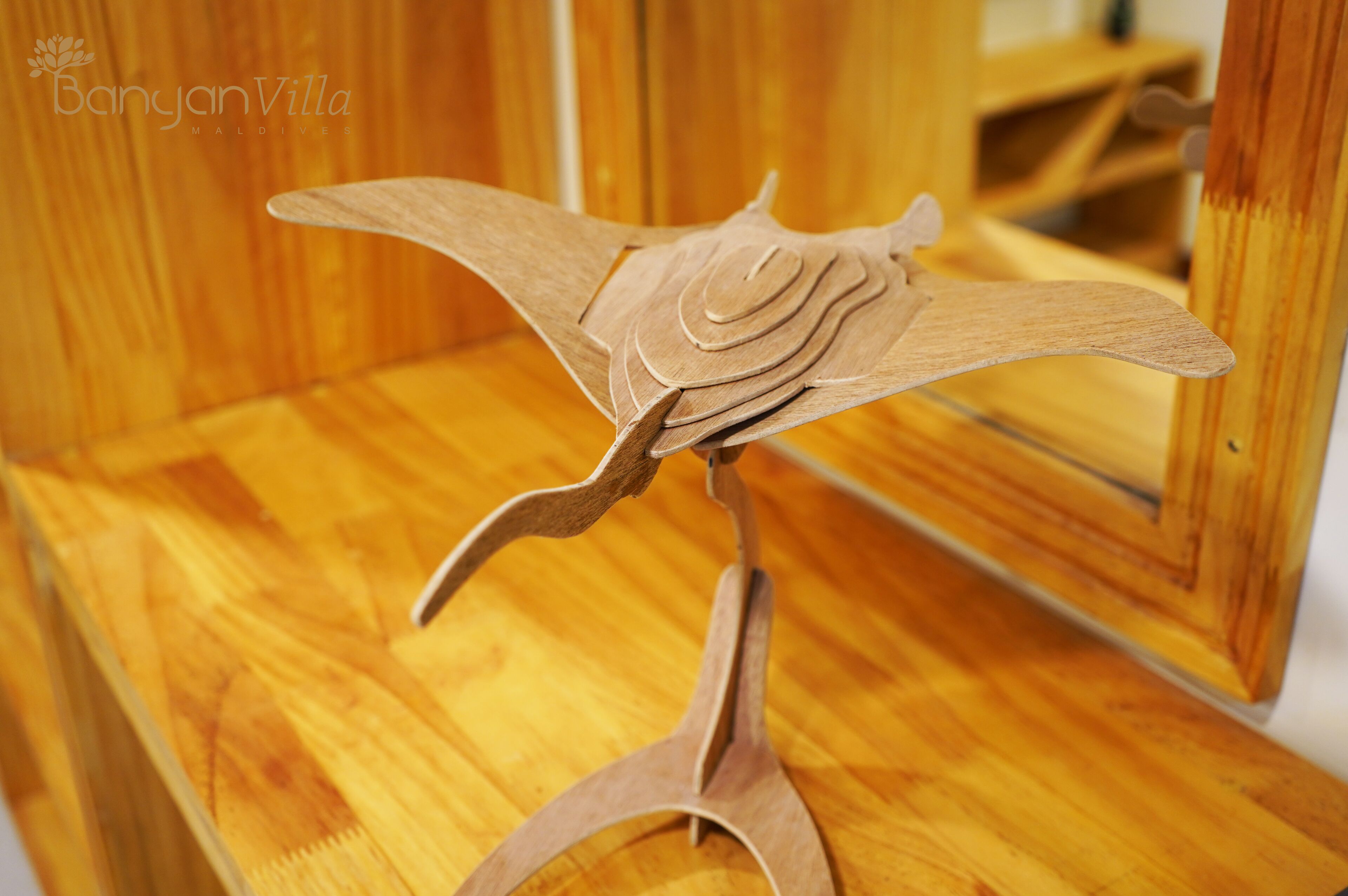 Eine Holzskulptur eines Vogels auf einem Sockel.