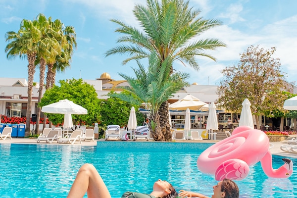 Una piscina al aire libre de temporada, sombrillas