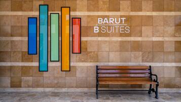 Un banco frente a una pared con un letrero que dice 'BARUT B SUITES'.