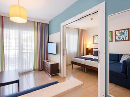Una habitación de hotel con cama, escritorio, televisor y sofá.