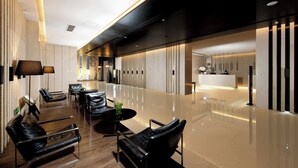 Un moderno vestíbulo de hotel con asientos de cuero, un mostrador de recepción y un piso pulido.