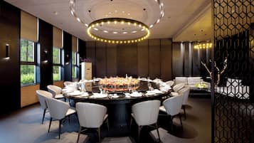 Un comedor moderno con una mesa redonda dispuesta para seis personas, rodeada de sillas blancas.